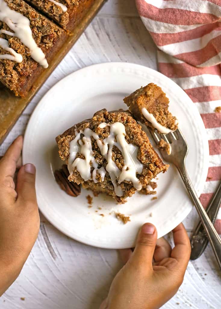 little hands holding a plate with a piece of paleo sweet potato pecan coffee cake on it 