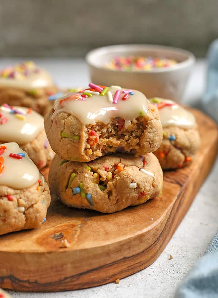 paleo birthday cake cookies stacked on each other with a bite taken out 