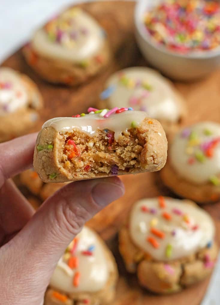 hand holding a paleo funfetti cookie with a bite taken out 