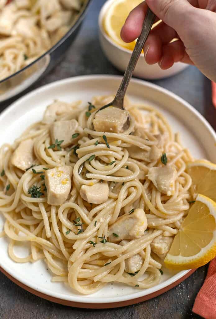 hand holding a fork taking a bite of gluten free lemon butter pasta 