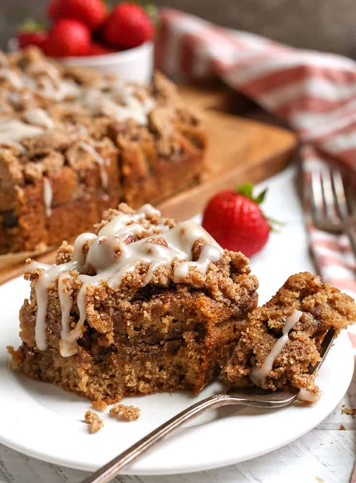 a piece of paleo coffee cake on a plate with a bite taken out 