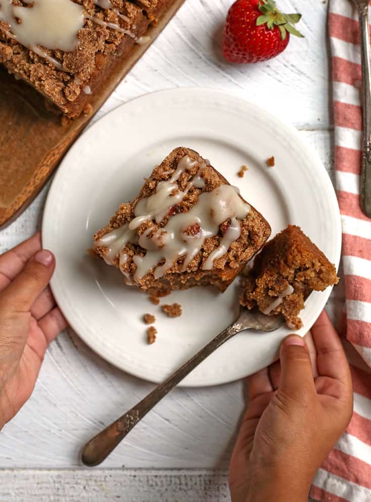 little hands holding a plate with a slice of coffee cake on it 