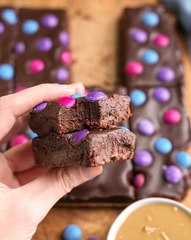 hand holding a stack of two paleo brownies with a bite taken out of the top one 