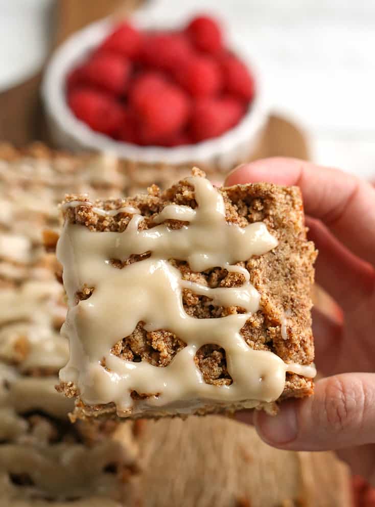 hand holding a piece of gluten free coffee cake, drizzle on top showing 