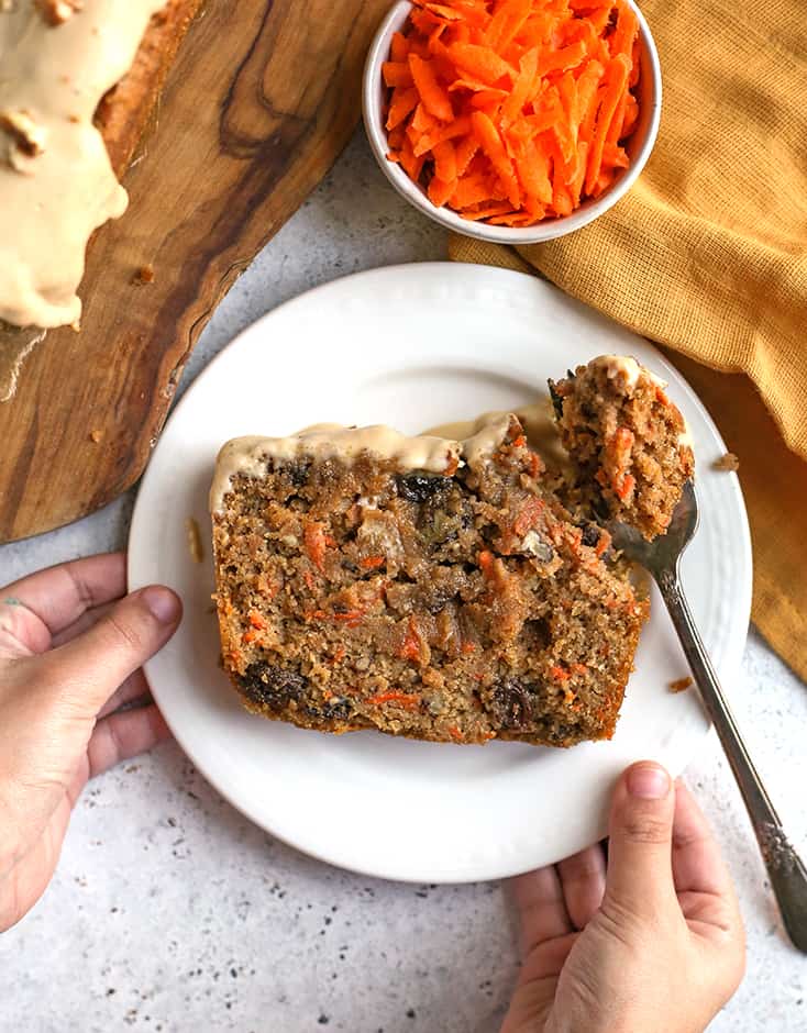 little hands holding a plate with a slice of healthy carrot cake bread 