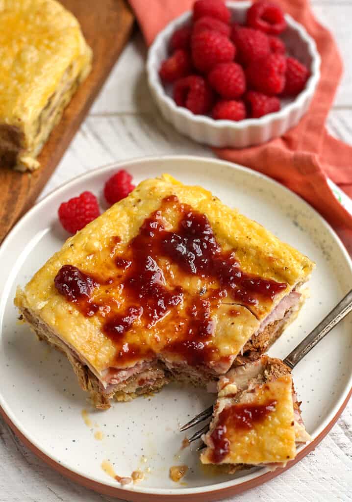 a slice of healthy monte cristo casserole on a plate with a bite taken out of it 