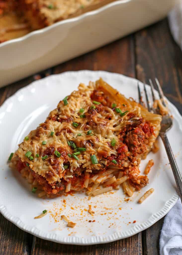 spaghetti pie on a plate with a bite taken out 