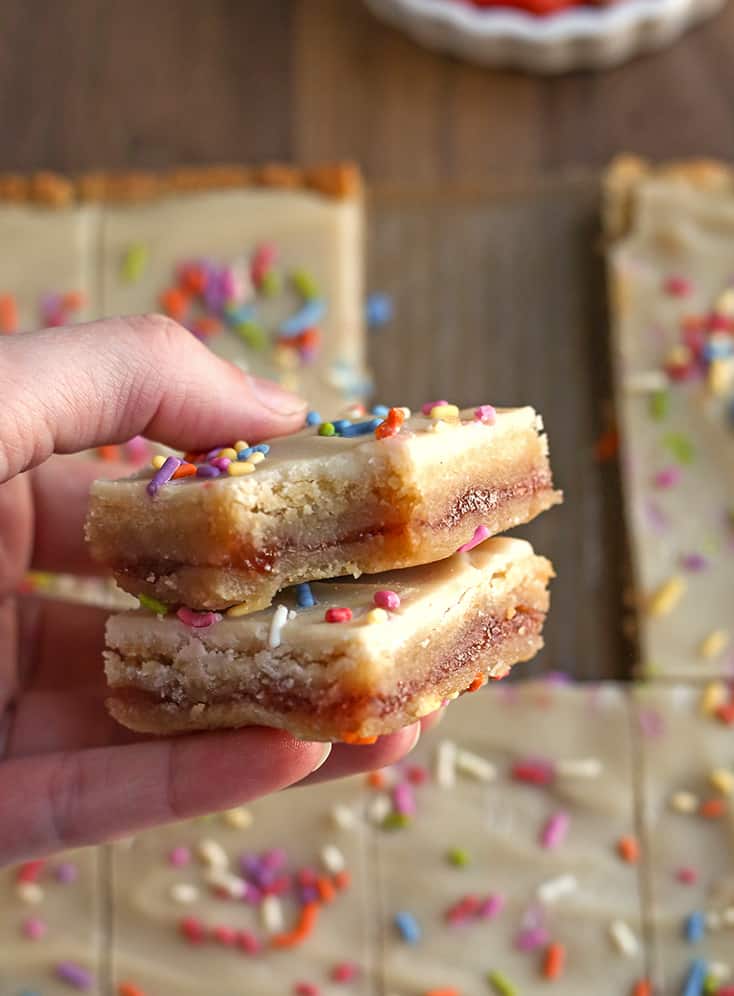 hand holding a stack of two paleo pop tart bars with a bite taken out of one 