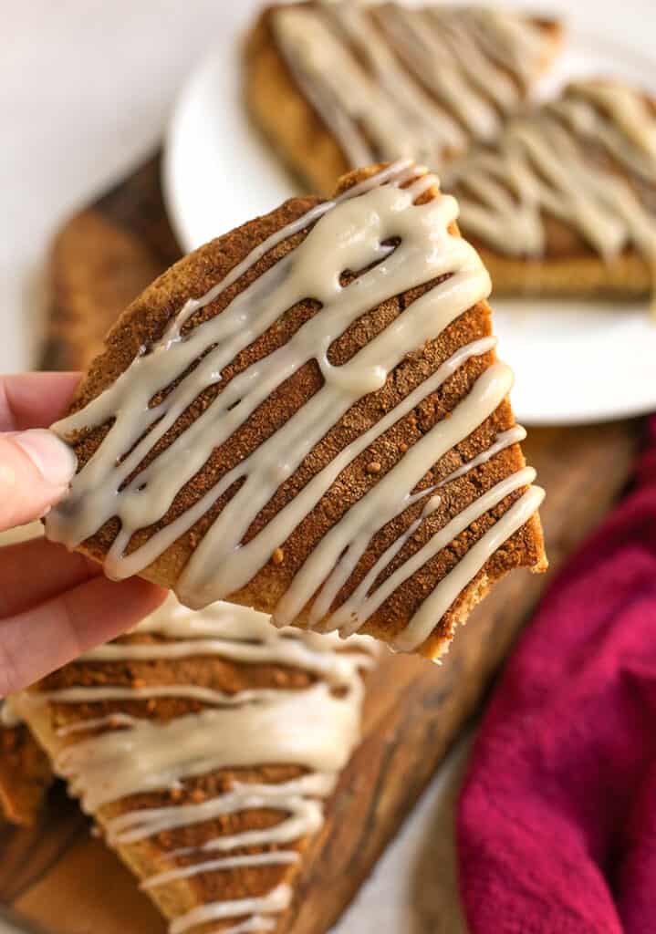 hand holding a paleo scone with a bite taken out of it 