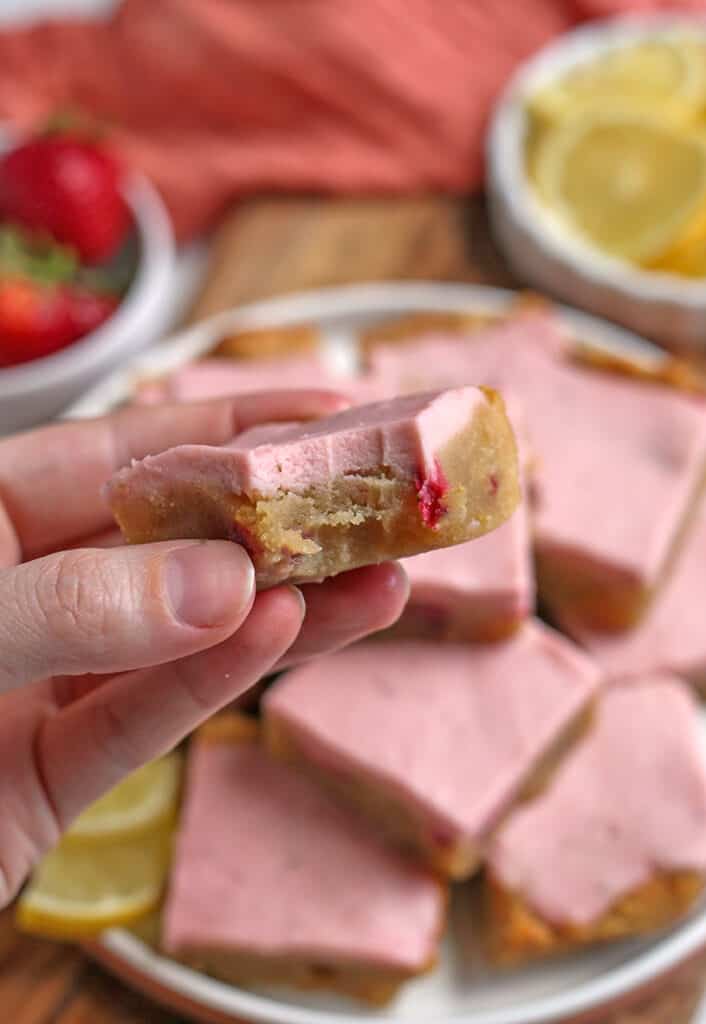 hand holding a paleo lemon bar with a bite taken out of it 