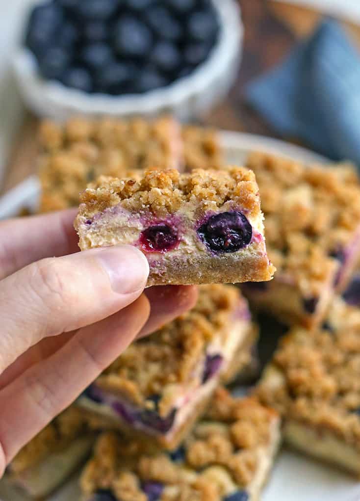 hand holding a grain free blueberry cheesecake bar