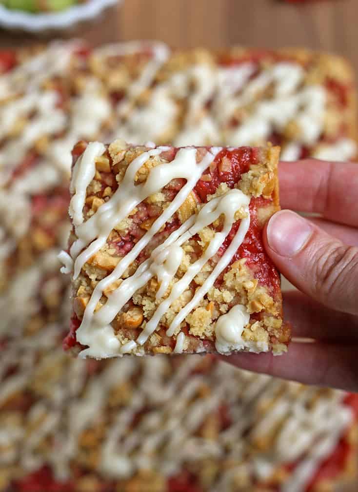 hand holding a vegan strawberry rhubarb pie bars 