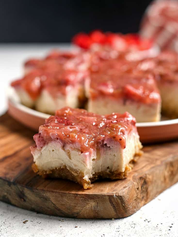 paleo vegan strawberry rhubarb cheesecake, with a bite taken out of one piece