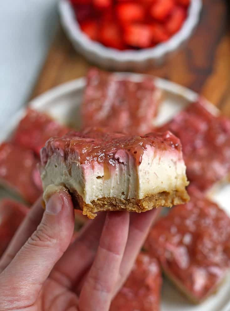 hand holding a piece of paleo strawberry rhubarb cheesecake 