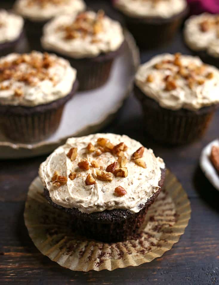 close view of grain free bourbon butter pecan cupcakes showing frosting and nuts on top 
