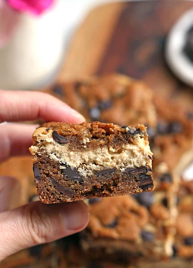 hand holding a gluten free chocolate chip cookie bar with the layers showing 