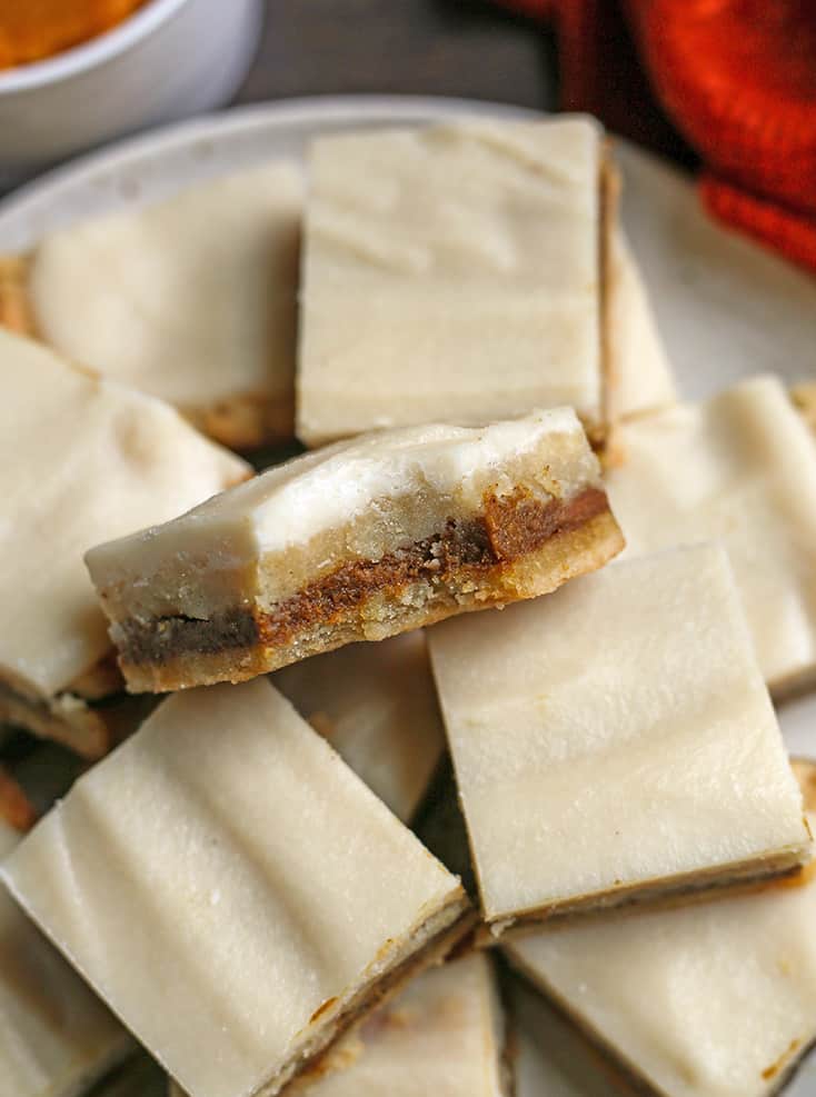 plate with paleo pumpkin pop tart bars, top one with a bite out showing the middle 