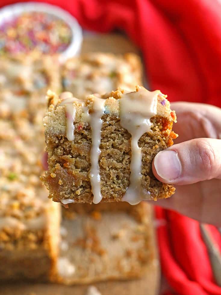 hand holding a piece of paleo coffee cake with glaze dripping 