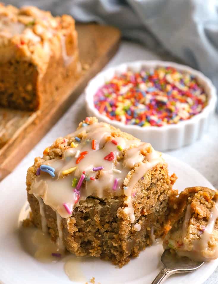 paleo funfetti coffee cake on a small plate with a bite taken out of it 