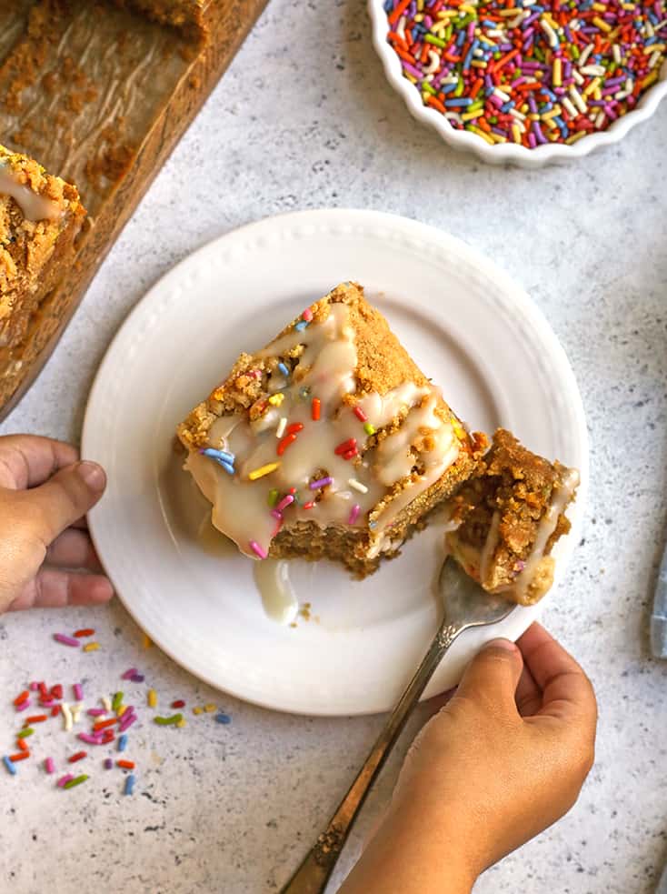 small hands holding a plate of paleo coffee cake, top view 