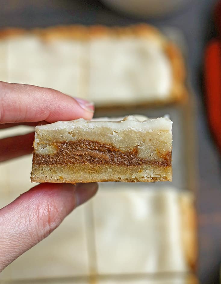 a hand holding a gluten free pop tart bar, showing the layers 