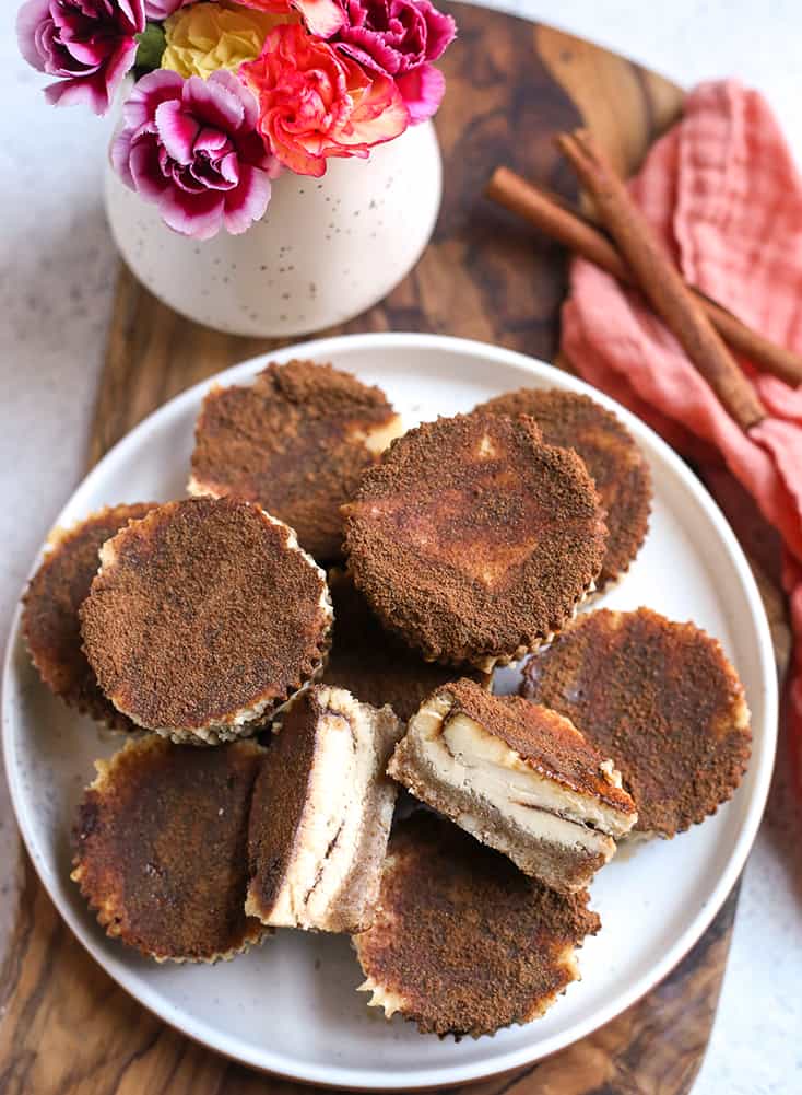 plate with mini cinnamon roll cheesecakes on it, one cut showing the center 