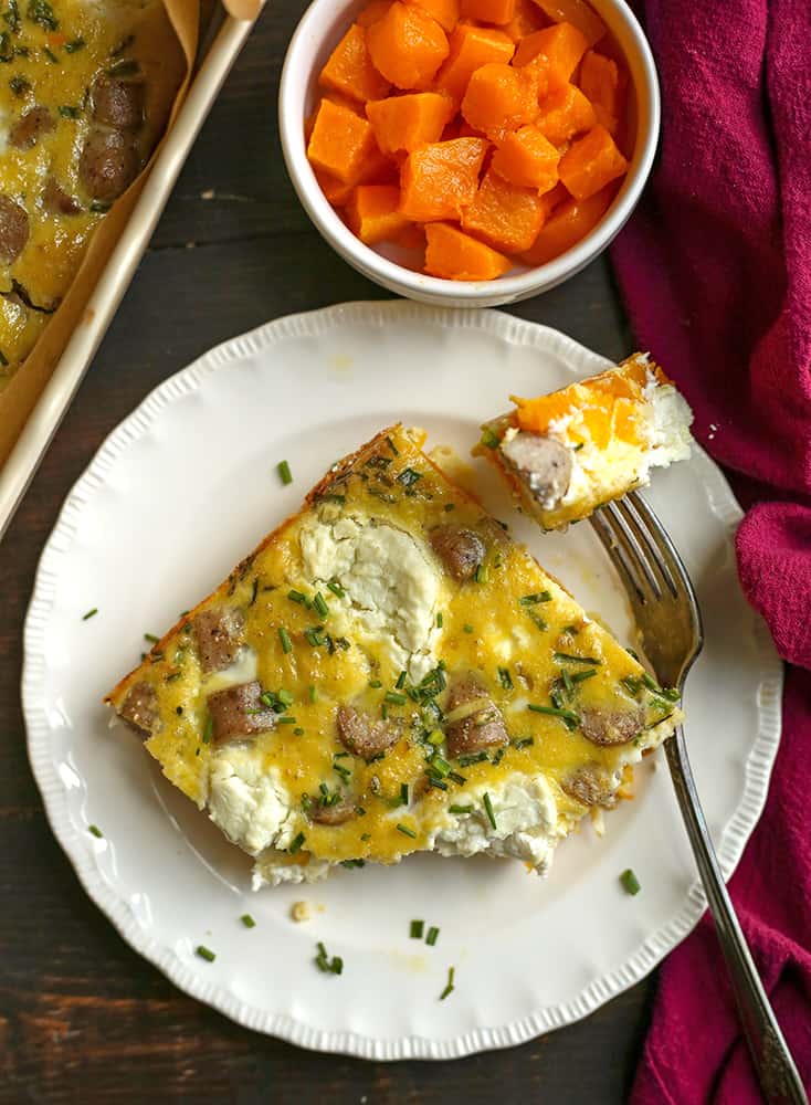 piece of goat cheese breakfast casserole on a plate with a bite taken out 