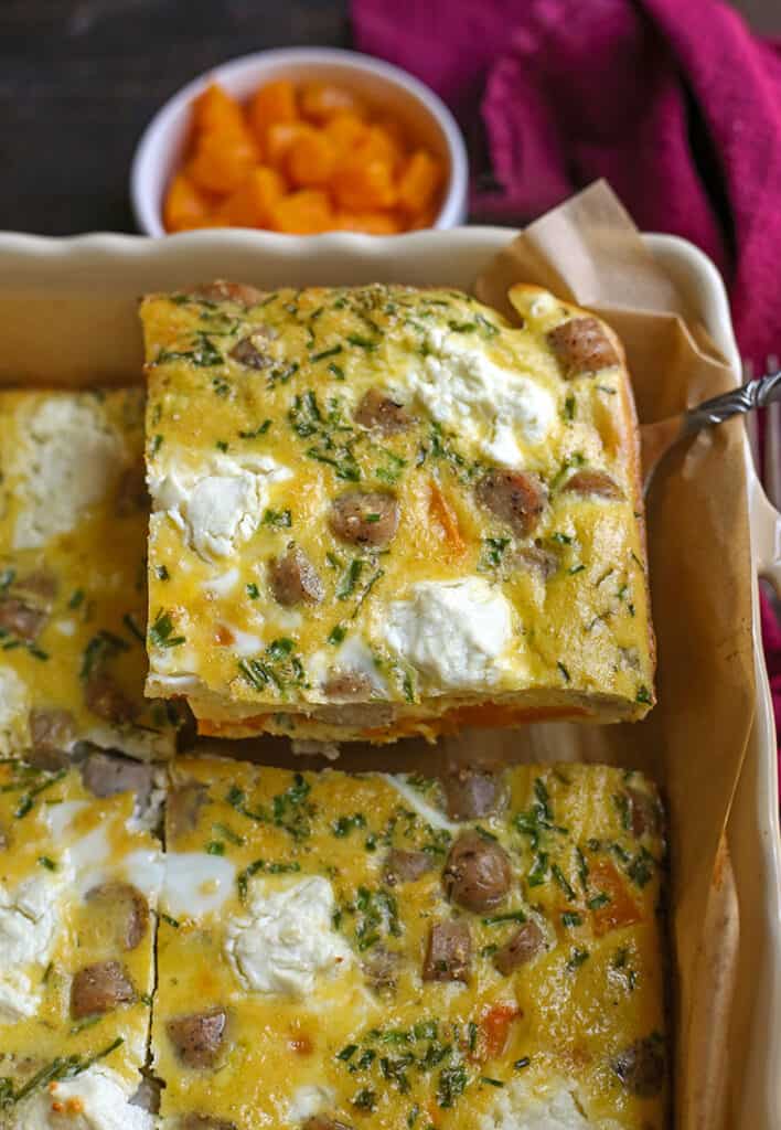 butternut squash egg bake in a pan with a piece being taken out 