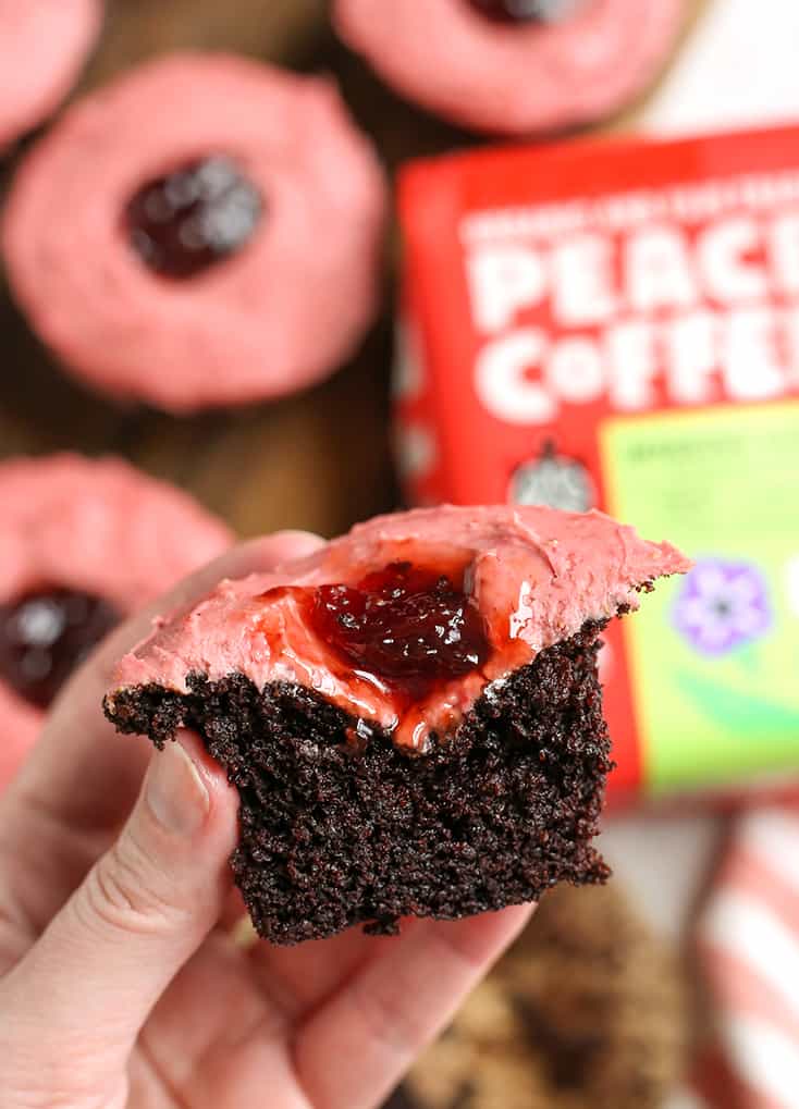 hand holding a grain free chocolate cupcake with strawberry frosting 