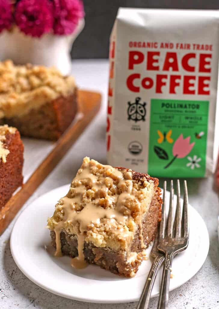 paleo raspberry coffee cake on a plate with coffee in the background 