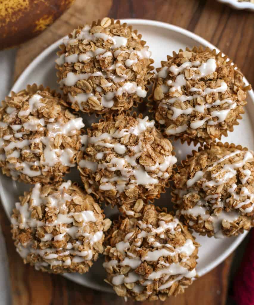 top view of banana oatmeal muffins on a plate, showing the oat crumble. 