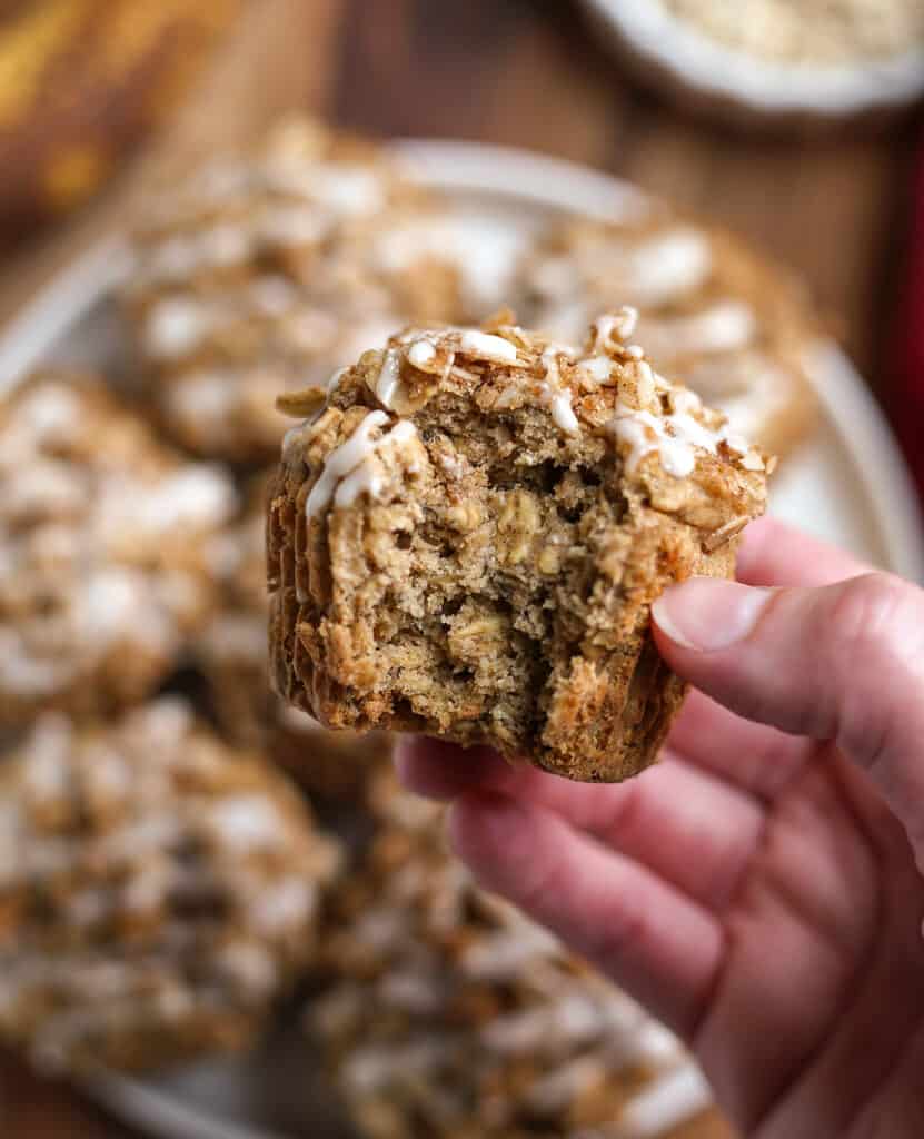 hand holding a banana oat muffin with a bite taken out. 