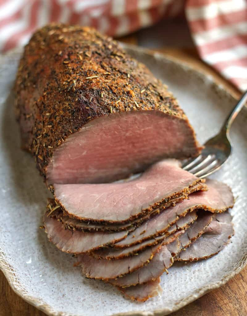 roast beef with 8 thin slices pilled in the front of it 
