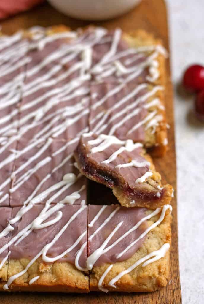 a pop tart bar on a cutting board with one propped up with a bite taken out of it. 