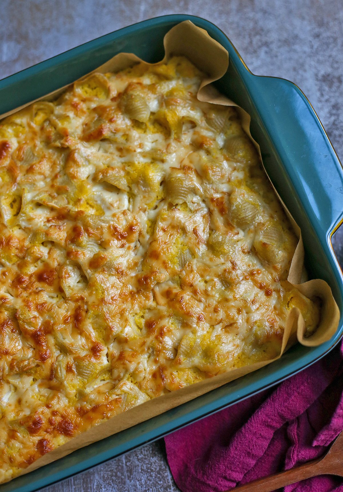 A pan of baked macaroni and cheese with a cheesy layer on top.